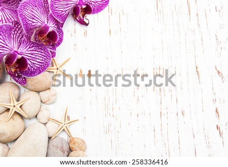 Orchids and massage stones on a wooden background