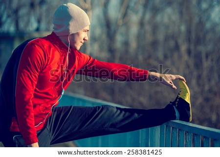 Athlete stretching out before jogging Royalty-Free Stock Photo #258381425