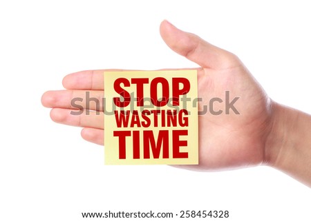Hand with Stop Wasting Time note is isolated on white background.