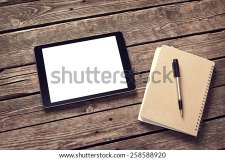 Tablet and notepad on desktop. Clipping path included.