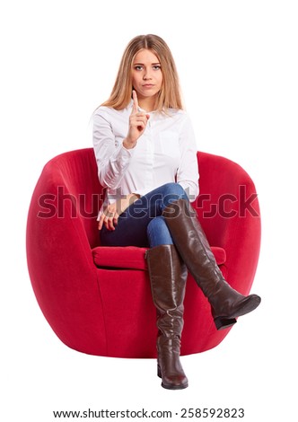 Young woman sitting in a red chair and makes a gesture