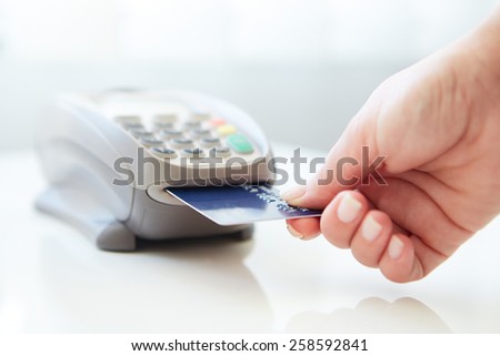 Woman pay by credit card in shop Royalty-Free Stock Photo #258592841