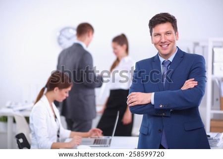 Successful business man standing with his staff in  office