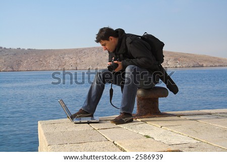 man using a photo camera and laptop