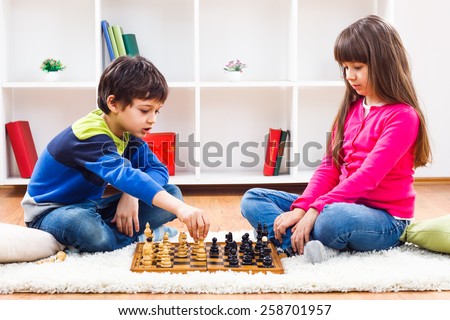 Little boy and little girl are playing chess at home.Children playing chess Royalty-Free Stock Photo #258701957