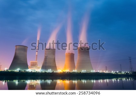power plant at night , cooling tower closeup with steam Royalty-Free Stock Photo #258734096