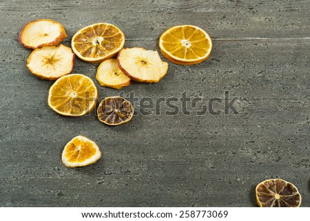 dried apple, lemon and orange slices on rusty dark wooden table