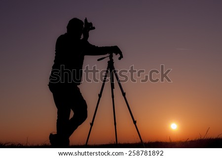 Silhouette photographer with sunset background