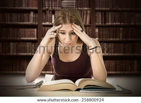 young beautiful college student girl studying busy for university exam worried desperate and in stress feeling tired and test pressure sitting on desk with book in youth education concept
