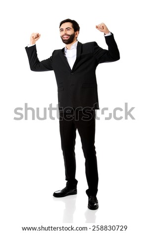 Successful businessman making fists in a winner gesture.