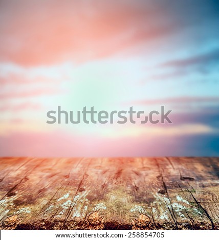 Rustic wooden table over sunset sky, nature background.