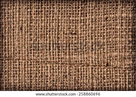 Photograph of raw, roughly woven, extra coarse grain, burlap vignette grunge texture. 