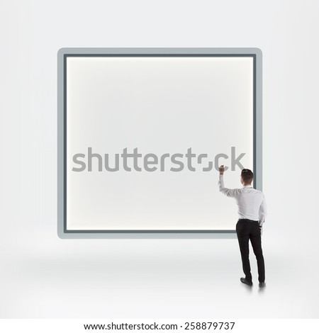 Businessman standing with back and writing on blank light box