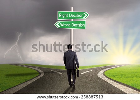 Businessperson with briefcase walking on the road and get two choices of the right decision or wrong decision