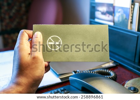 Hand holding card with no smoking sign