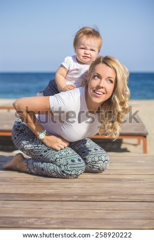 Mom plays with the child on a background of the sea