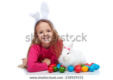 Happy girl with her easter rabbit and colorful dyed eggs - isolated
