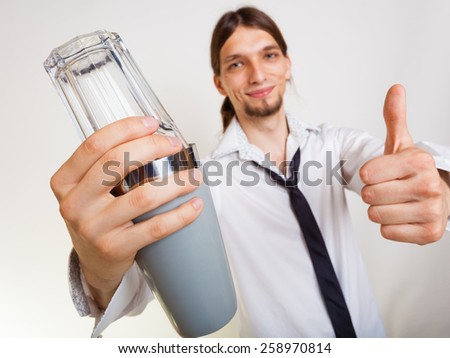 Happy man bartender with shaker making alcohol cocktail drink thumb up gesture studio shot on gray