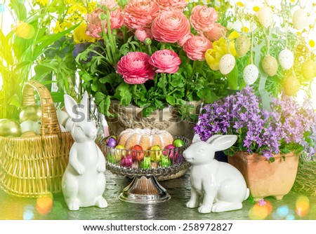 Easter cake, spring flowers, eggs and bunny. Festive home decoration. Retro style toned picture with light leaks