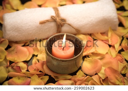 rose petals with candle in bowl with towel
