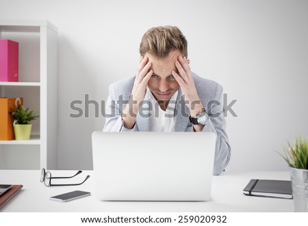 Depressed businessman sitting at computer Royalty-Free Stock Photo #259020932
