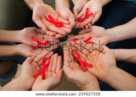 Close-up Of People Holding Red Aids Awareness Ribbon On Palm Royalty-Free Stock Photo #259027358