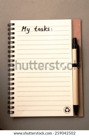 Hand drawing task list on notebook from recycling paper on grey background