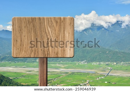 Blank wooden sign on field of farm. Concept of rural, idyllic, tranquility etc.