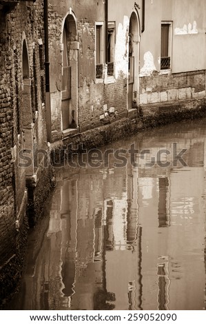 Venice houses reflection in canal. Curve. Aged photo. Sepia.
