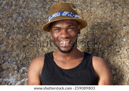 Close up portrait of a handsome young african american man smiling with hat