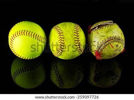The life cycle of the softball. Three softballs on a different stage of use