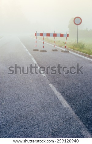 Highway road blurring in the fog. Road signs. 