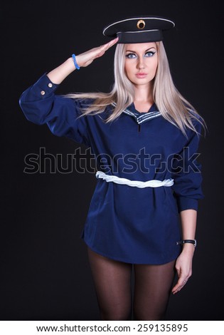  Saluting woman in the marine uniform over black background