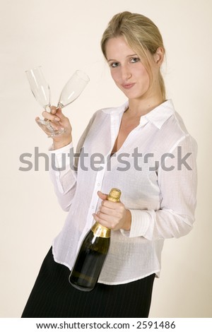 Young woman in business clothes with a bottle of champagne and two glasses against a white background