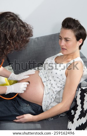 Consultation of pregnant young woman with a nurse at home