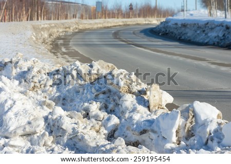 A pile of dirty snow on the side of the road
