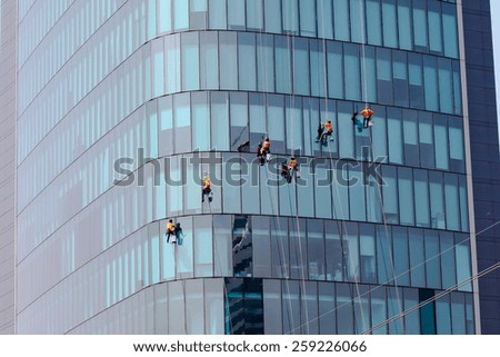 Washers wash the windows of modern skyscrape Royalty-Free Stock Photo #259226066