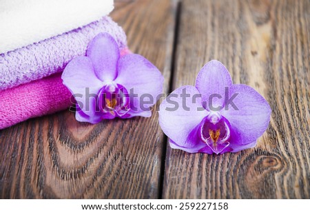 Bathroom soft and fresh towels with orchid on a wooden background