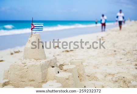 Cuban Sandcastle with the country Flag on one of the most Beautiful Beach of Cuba with tourists in background