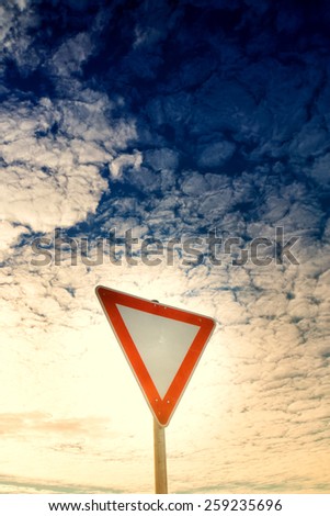 give way road sign, yield sign, with blue sky and clouds