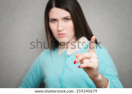 portrait of long-haired girl who warns finger
