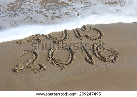 New Year 2016 is coming concept - inscription 2015 and 2016 on a beach sand, the wave is almost covering the digits 2015 Royalty-Free Stock Photo #259247495