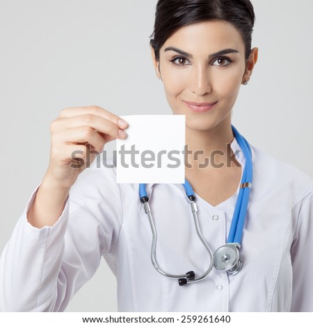 Smiling medical doctor woman with empty blank in hands.