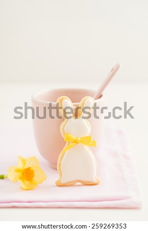 Easter bunny sugar cookie with bow tie and a pink cup