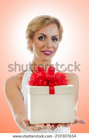 Young happy woman with a gift on color background