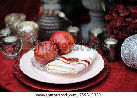 Stylish red table set with natural pomegranates