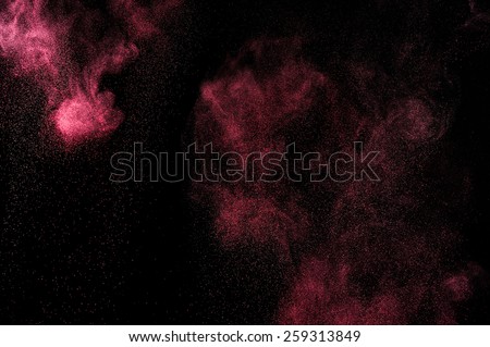 Abstract pink powder explosion on black background.