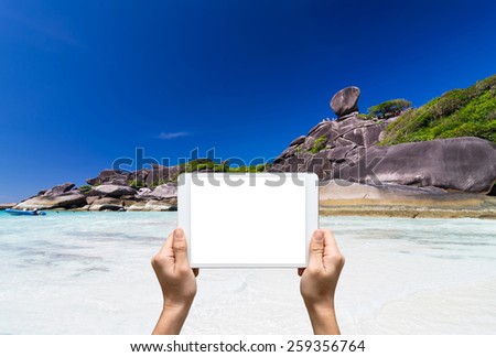 Female hands holding tablet taking pictures Similan islands, Beautiful view of the rock Sail, Thailand