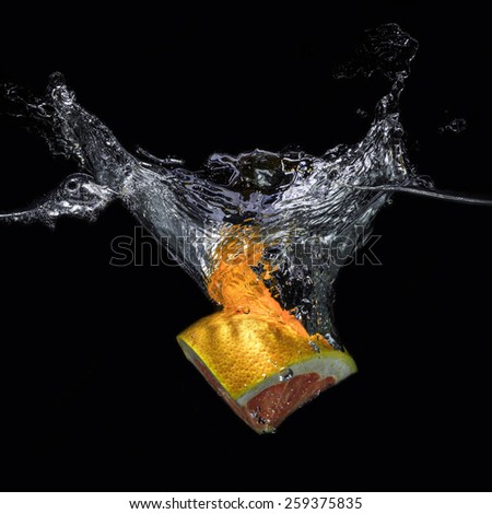 Grapefruit slice in water on a black background