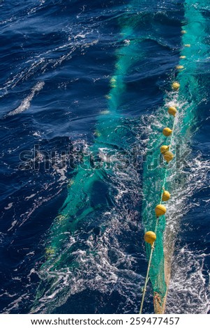 Hauling otter trawl fishing nets on the Atlantic Sea 